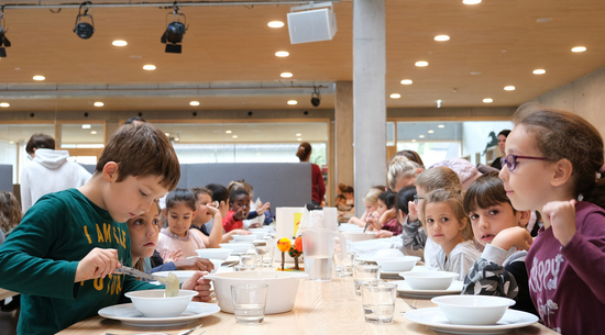 Auf dem Foto sind Kinder am Essen bei der Mittagsbetreuung zu sehen. 