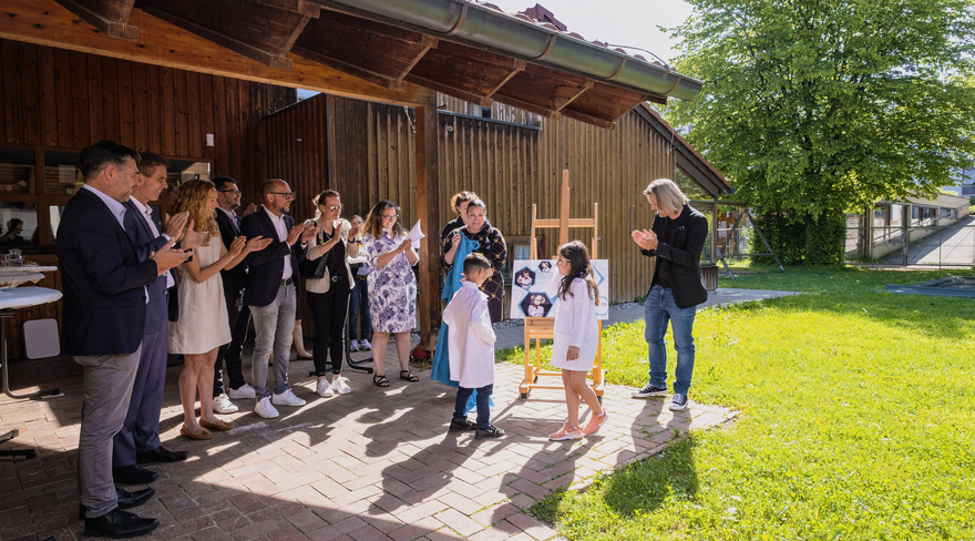 Diese Abbildung zeigt Bürgermeister Michael Ritsch, andere Personen und Kinder im Außenbereich des Kindergartens an der Ach.