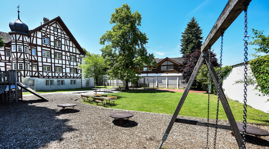 Das Bild zeigt den derzeitigen Kindergarten Weinschlössle (Bildmitte) neben dem dortigen Fachwerkbau (links).