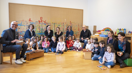 Auf dem Bild sind Kinder mit Instrumenten und Bürgermeister Michael Ritsch und Vertreter:innen der Verwaltung zu sehen. 