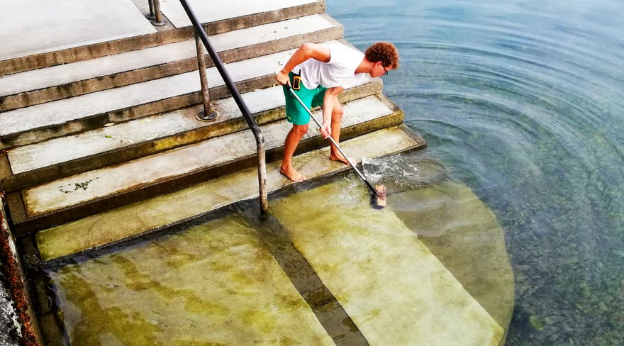 Diese Abbildung zeigt einen Herrn bei der Reinigung einer Stiege am See.