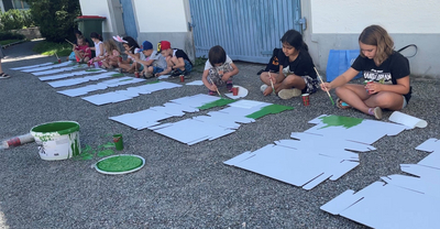 Auf dem Bild sind Kinder zu sehen, die am Rahmenprogramm "Malen mit Uwe" teilgenommen haben. 