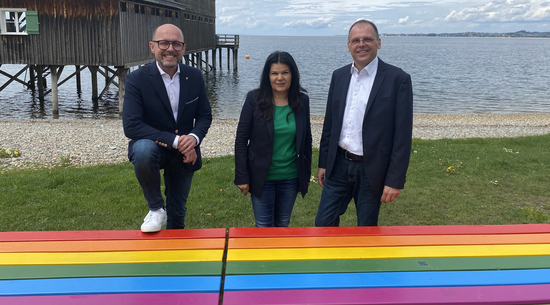 Bürgermeister Michael Ritsch, Vizebürgermeisterin Sandra Schoch und Stefan Becker, LGBTIQ+ Koordinator freuen sich über die neue Regenbogenbank beim Mili. © Stadt Bregenz