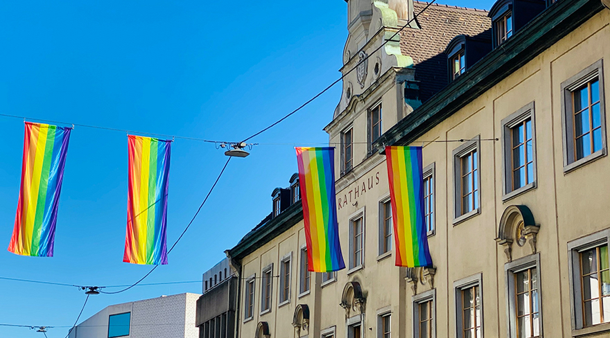Hier abgebildet sind Regenbogenfahnen, welche über der Straße vor dem Rathaus aufgehängt wurden.