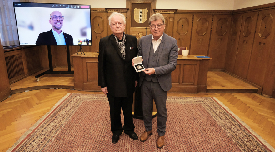 Diese Abbildung zeigt Festspiel-Vizepräsident Wilhelm Muzycyn, welcher Alfred Wopmann die "Hugo von Montfort Medaille" übergibt. Auch Bürgermeister Michael Ritsch ist per Zoom-Call virtuell anwesend.