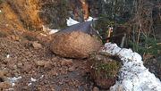 Auf dem Foto ist eine beschädigte Straße durch einen Felssturz zu sehen. 