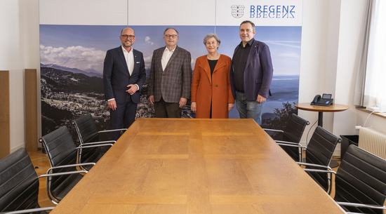 Bürgermeister Michael Ritsch mit Dr. Christoph Breier, Dr. Reingard Breier und Stadtrat Florian Rainer mit dem Tisch im Stadtratszimmer. @Stadt Bregenz