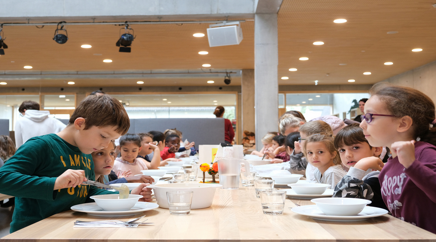 Auf dem Foto sind Kinder am Essen bei der Mittagsbetreuung zu sehen. 